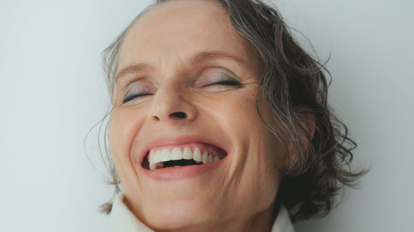 A smiling woman with short dark gray hair